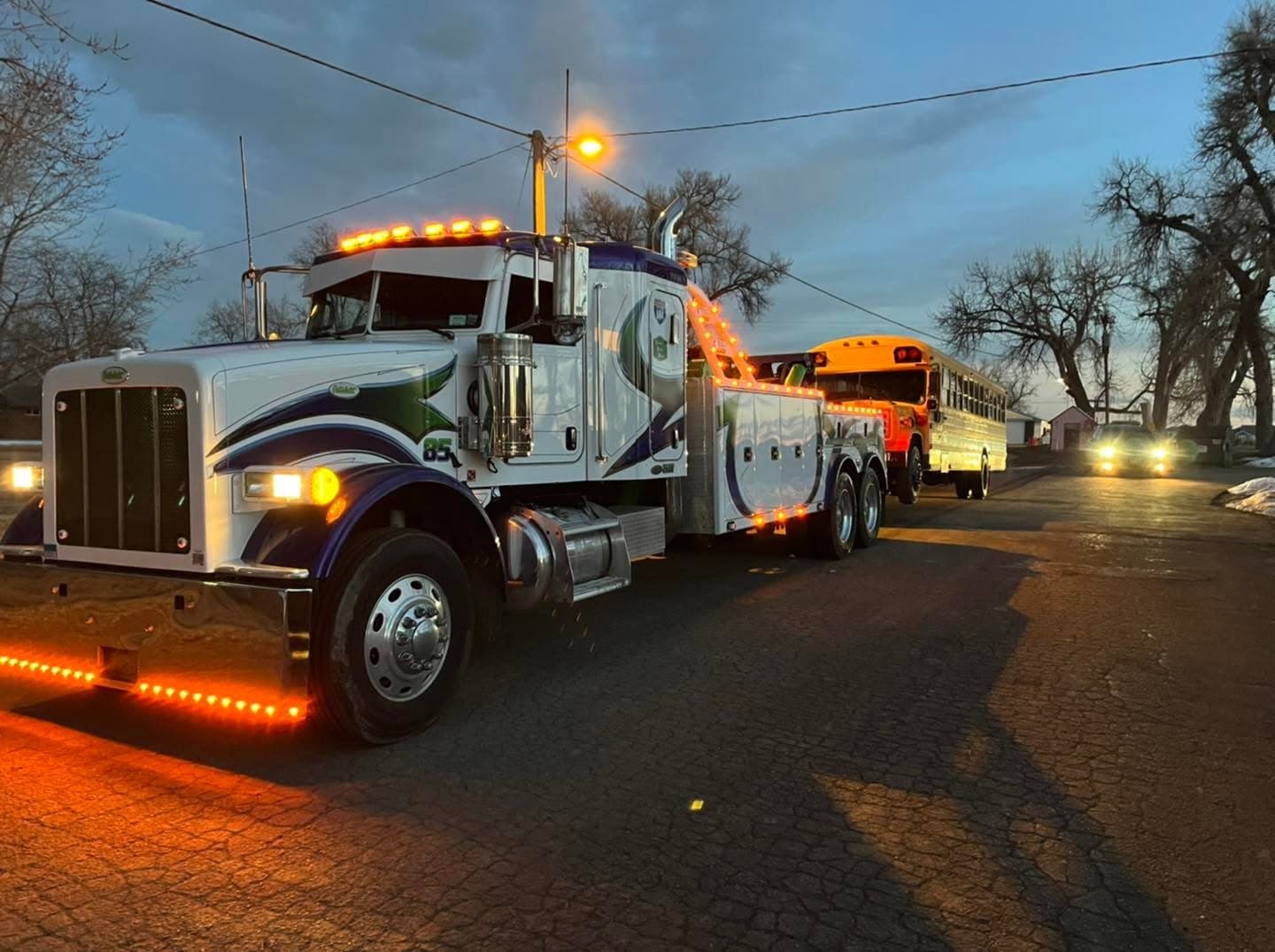 Spartan wrecker on the roadside at dusk with emergency lights on