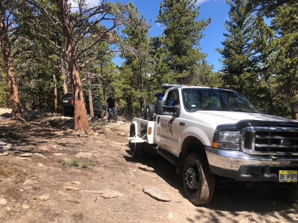 Service truck on a dirt road in a coniferous forest